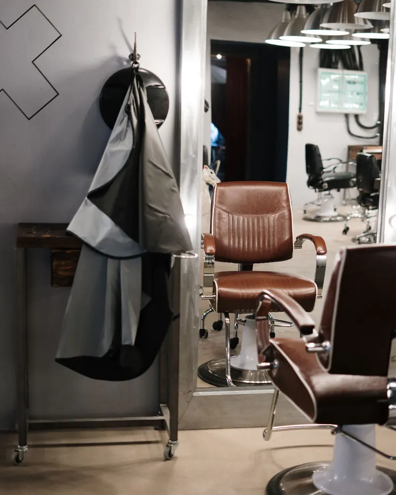A barber shop, with capes hanging beside the chairs